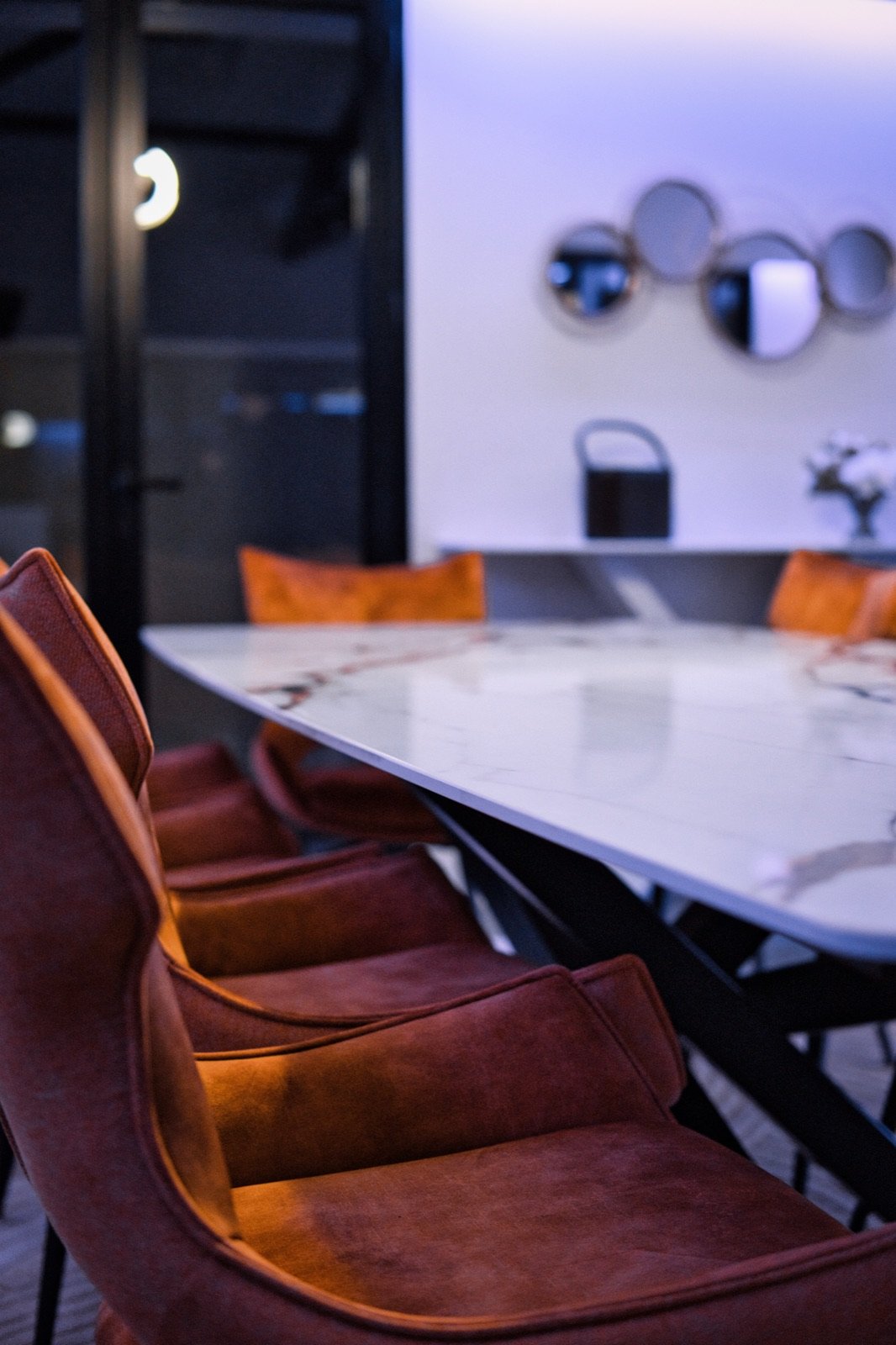 Table à manger en marbre et chaises en cuir dans une pièce de vie