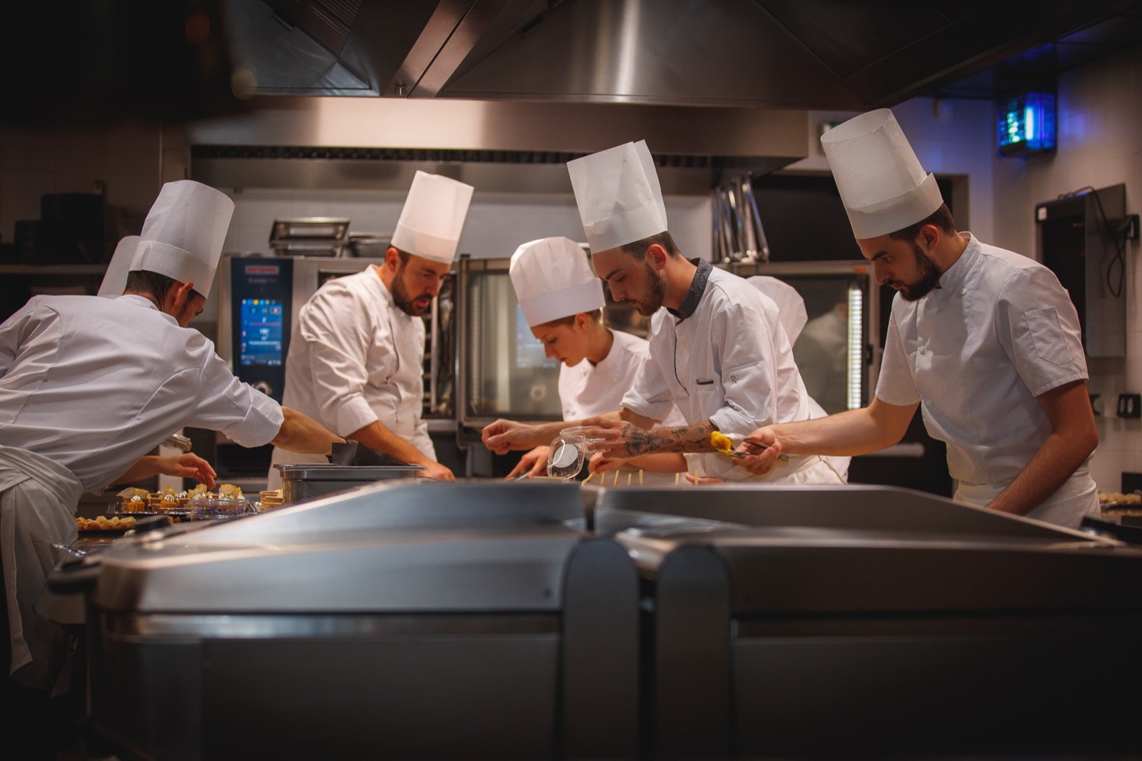 Brigade de cuisiniers au travail dans une cuisine professionnelle