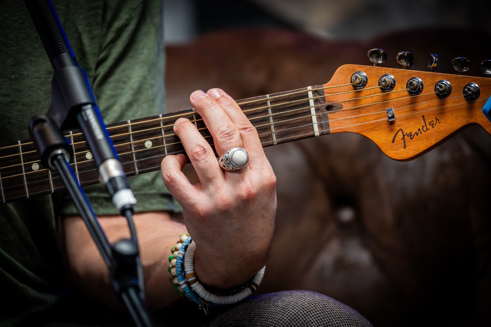 Main sur le manche d'une guitare, micro au premier plan